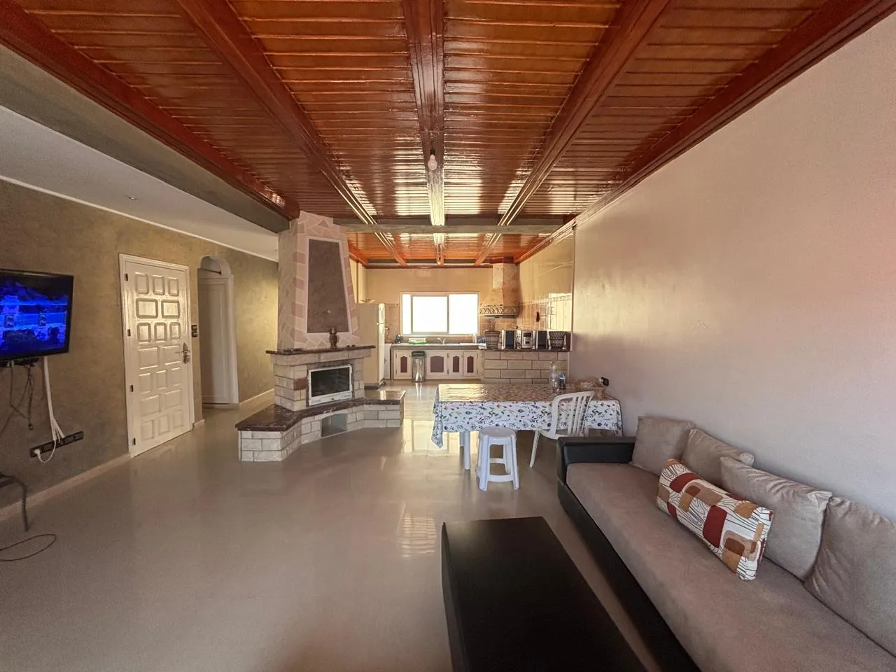 Darcom Loft à Saïdia — séjour ouvert, canapé et cheminée