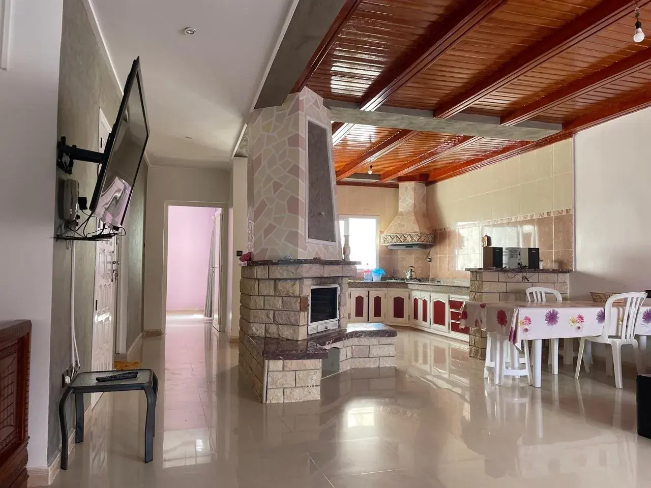 Le Loft à Saïdia — séjour ouvert avec cheminée et cuisine